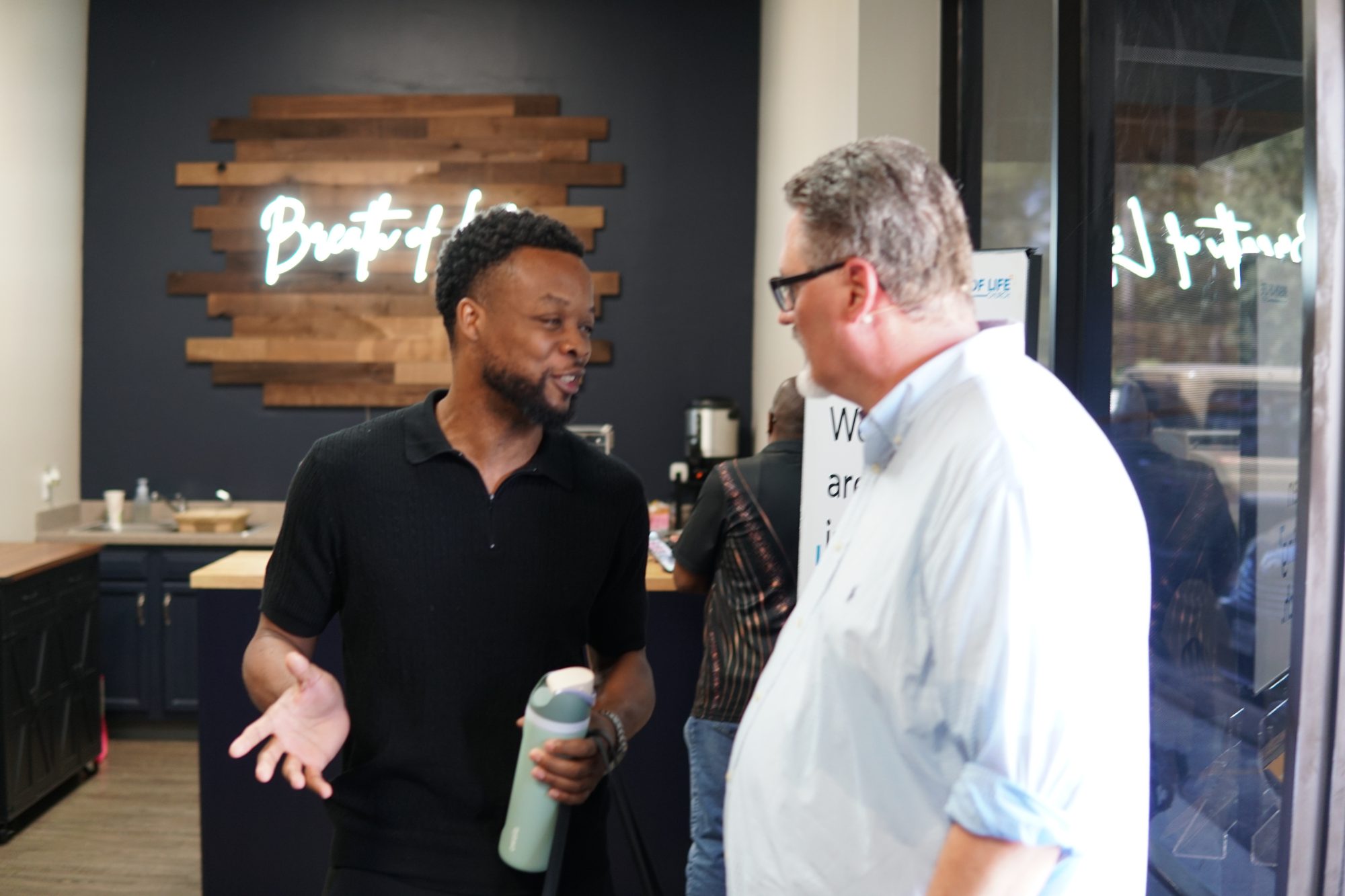 Pastor Justin talking with a guest in the lobby of Breath of Life Church
